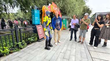 DEEP Robotics' DR02 humanoid robot poses with tourists during field trials in Hangzhou's Xihu district (Photo: DEEP Robotics)